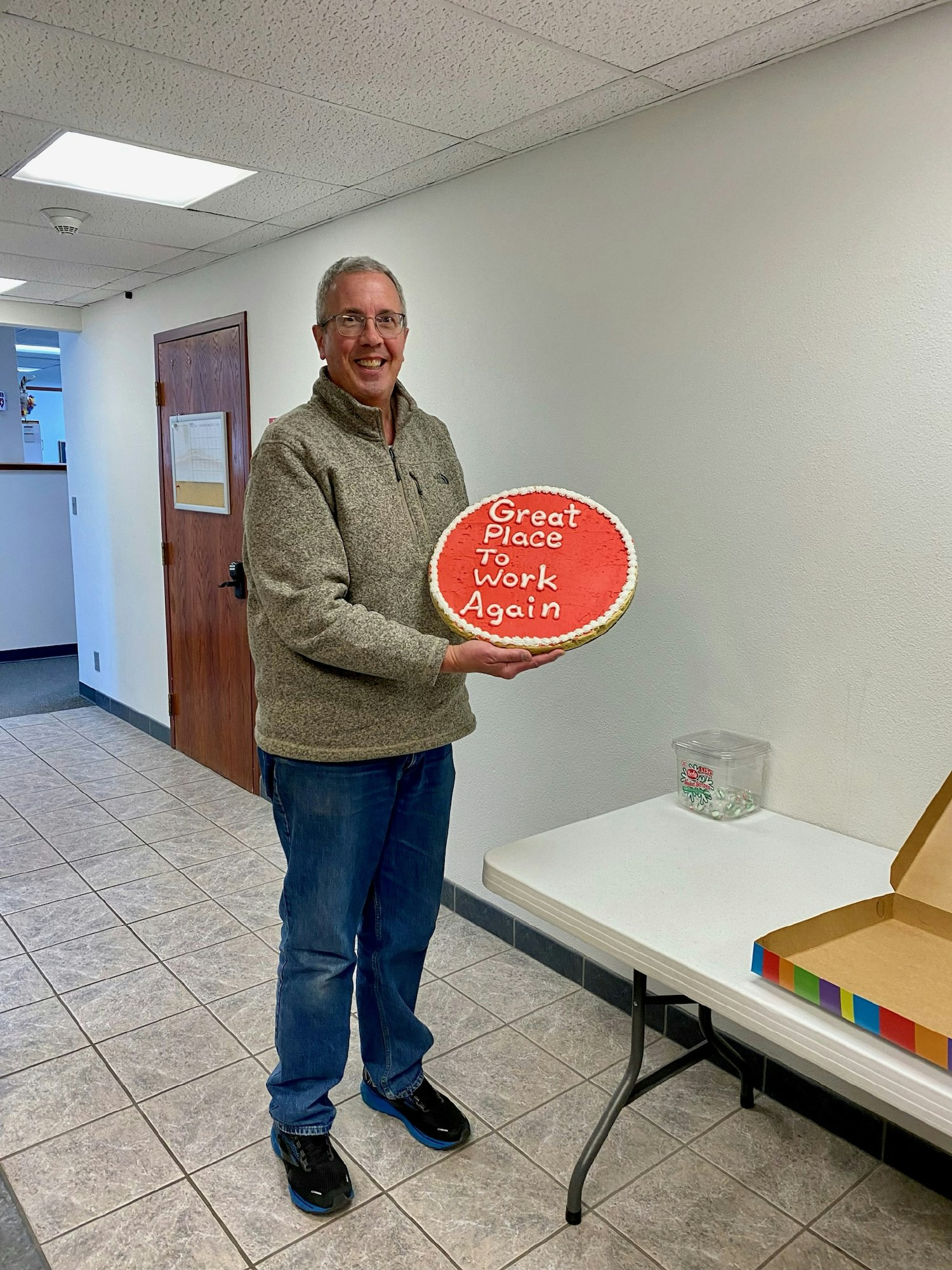 Our Executive Director, showing off our Great Place To Work certification with a customized cookie!