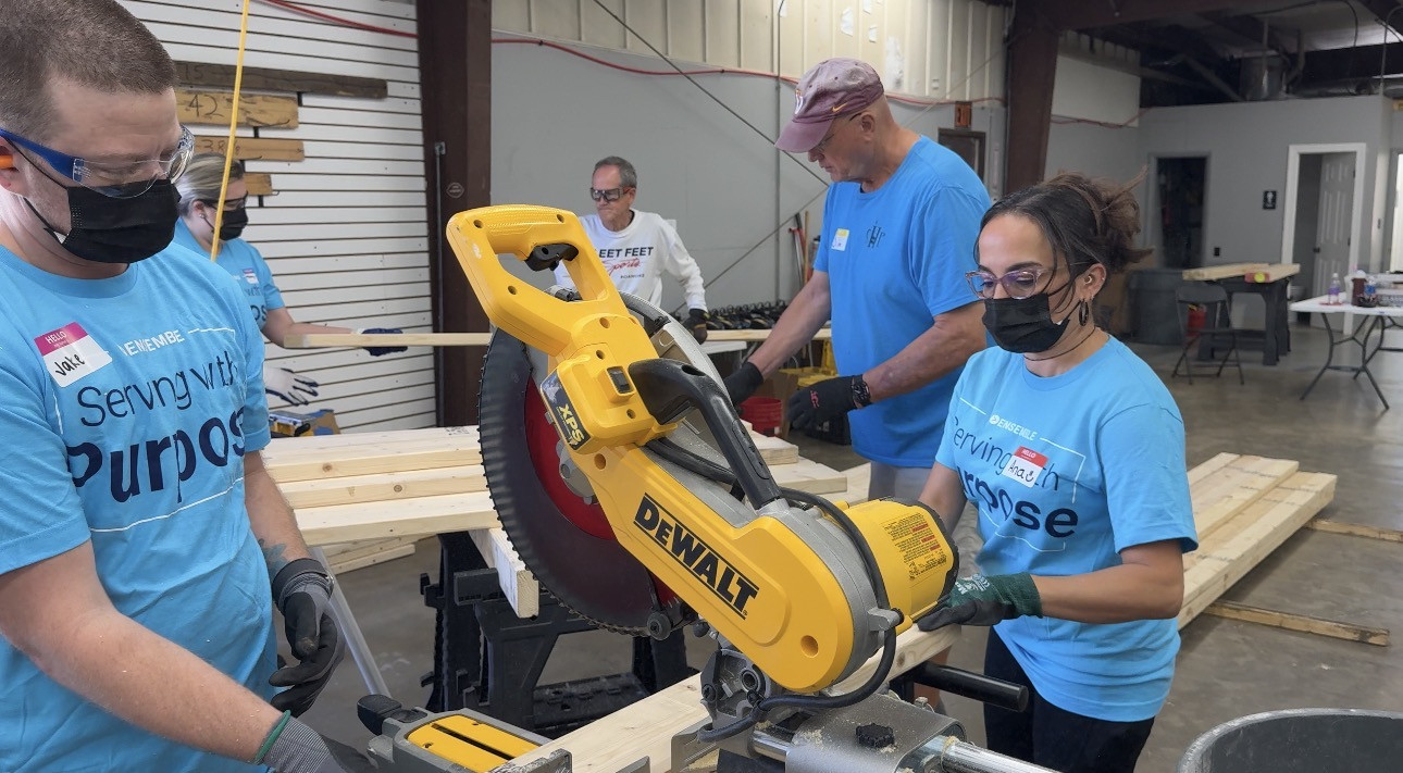 Associates cut lumber at the Sleep in Heavenly Peace volunteer event in Roanoke, Virginia.