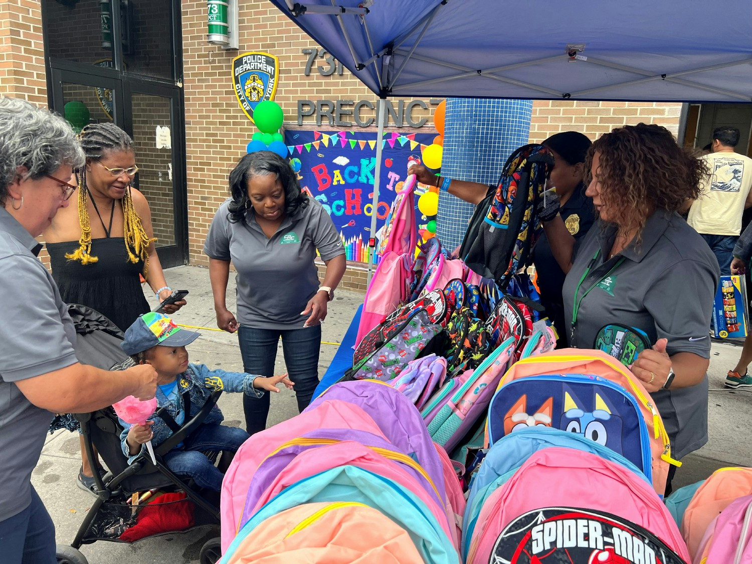 C.A.C. donates 100 backpacks filled with school supplies to the 73rd Precinct's backpack giveaway.