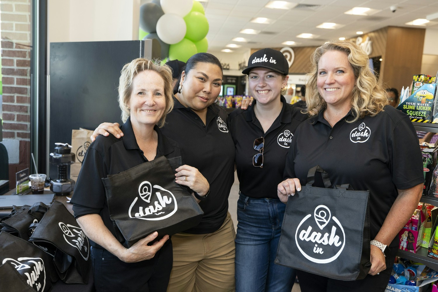 Dash In employees smiling proudly, showcasing our commitment to supporting each other and delivering the best experience