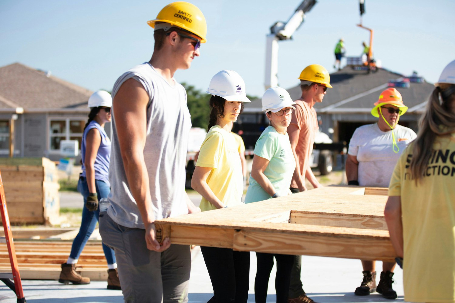 Team members work together to help construct a house during a volunteer event for Habitat for Humanity.