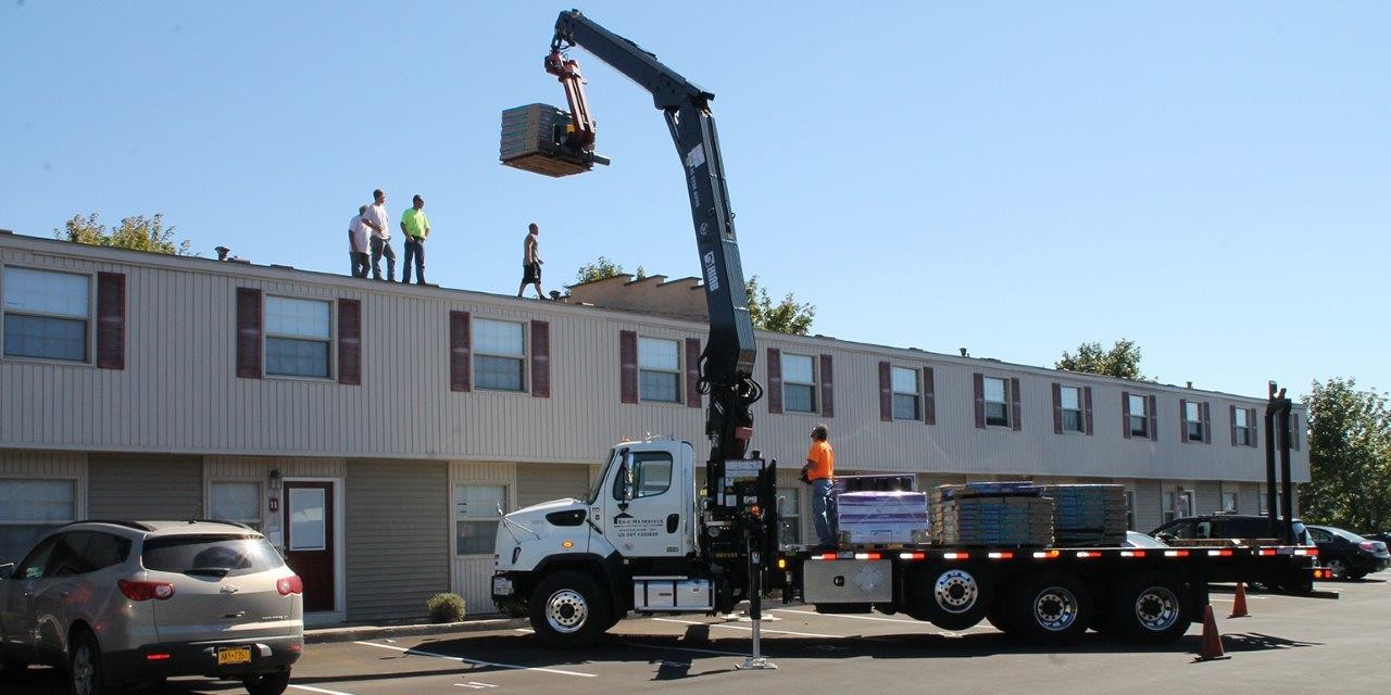 One of our specialized boom truck drivers making a shingle delivery to one of our customers.  