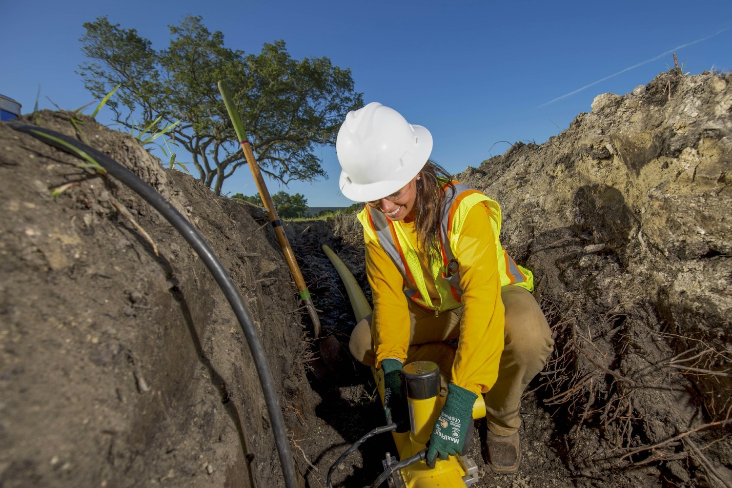 A student in our Natural Gas Program practices underground pipe installation during training. 