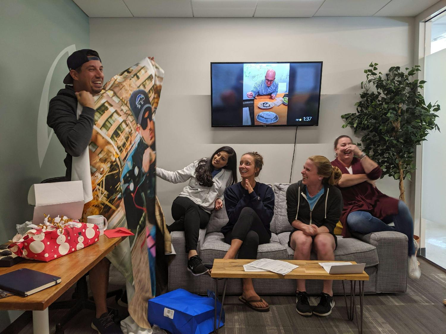 We laugh and celebrate often. Here Aaron opens a b-day blanket featuring a larger-than-life photo of him on a scooter.