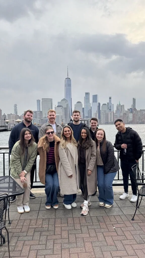 Sales Development team posing with the NYC skyline after a day of learning, connection, and strategic planning