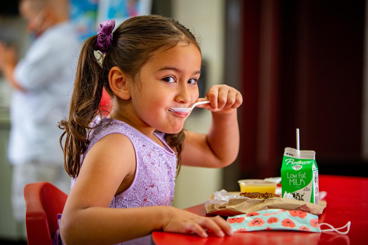 Student Enjoying Breakfast Provided by her School