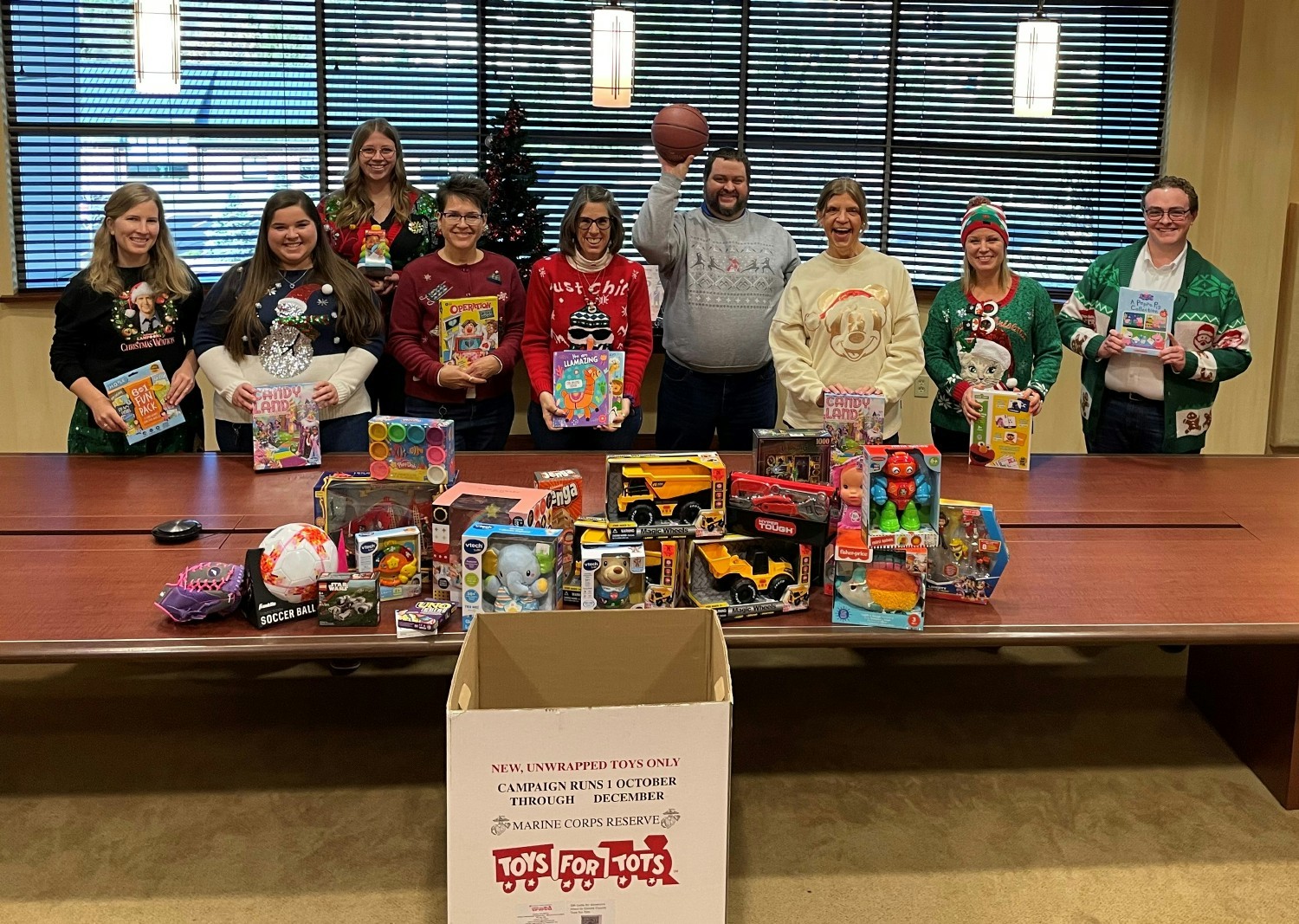 With a joyous spirit, staff members collect gifts for Toys for Tots.