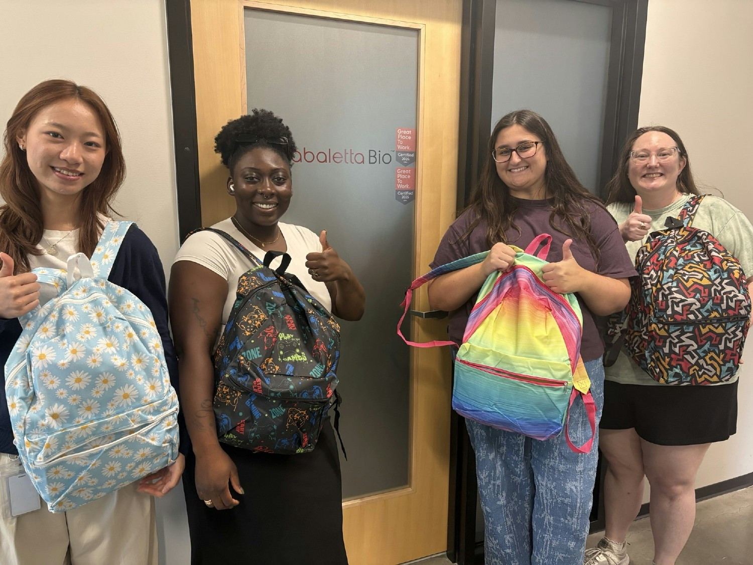 Crew showing off some backpacks stuffed with donated back to school supplies for children in the Philadelphia community