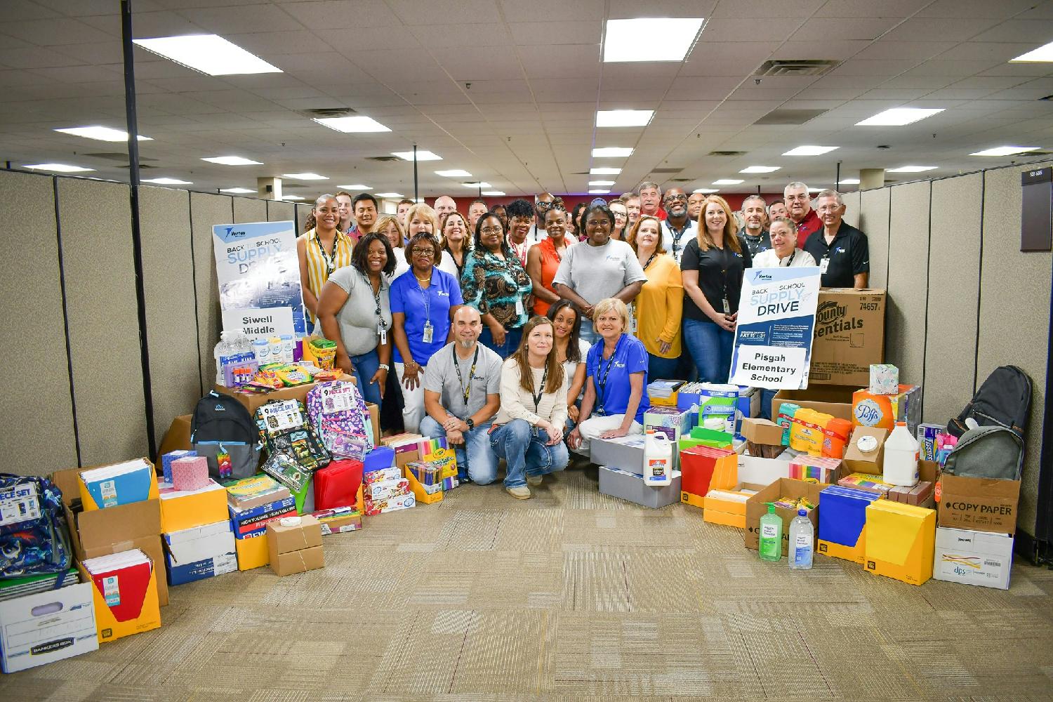 Employees of Vertex Aerospace donate their time and money to a Company-led supply drive for a local school in need. 