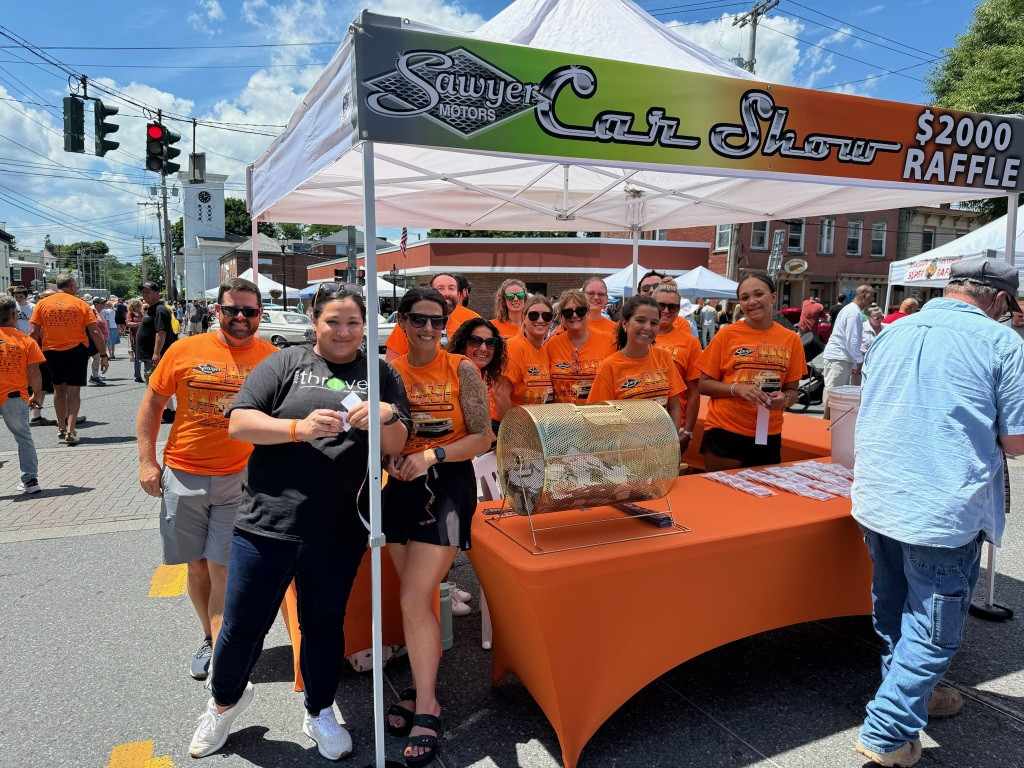 A group of employees volunteer each year to support a local car show that raises funds for local children in July 2024.