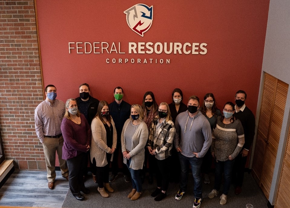 The team takes a photo in the lobby of the new headquarters office. 