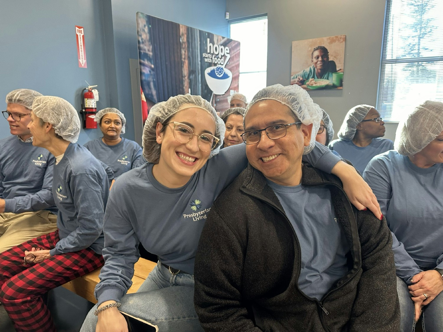 Corporate team members volunteering at Feed My Starving Children for corporate holiday event