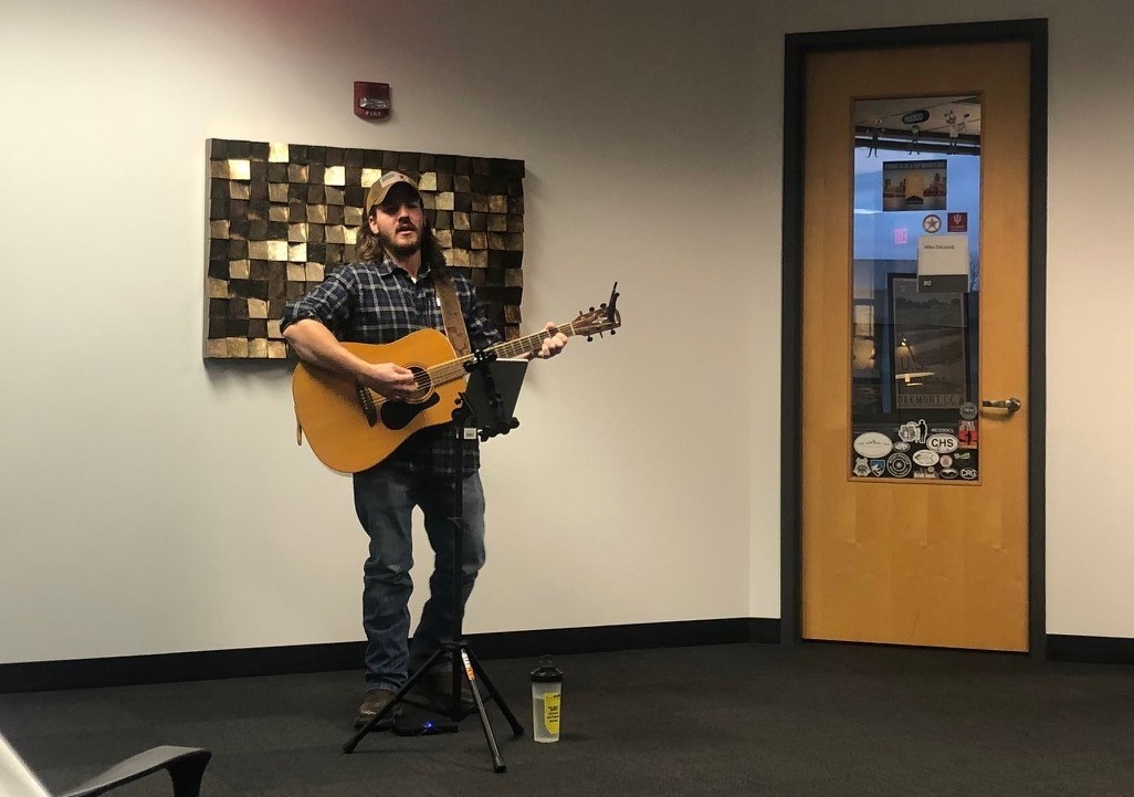 A team member performing live music for the office