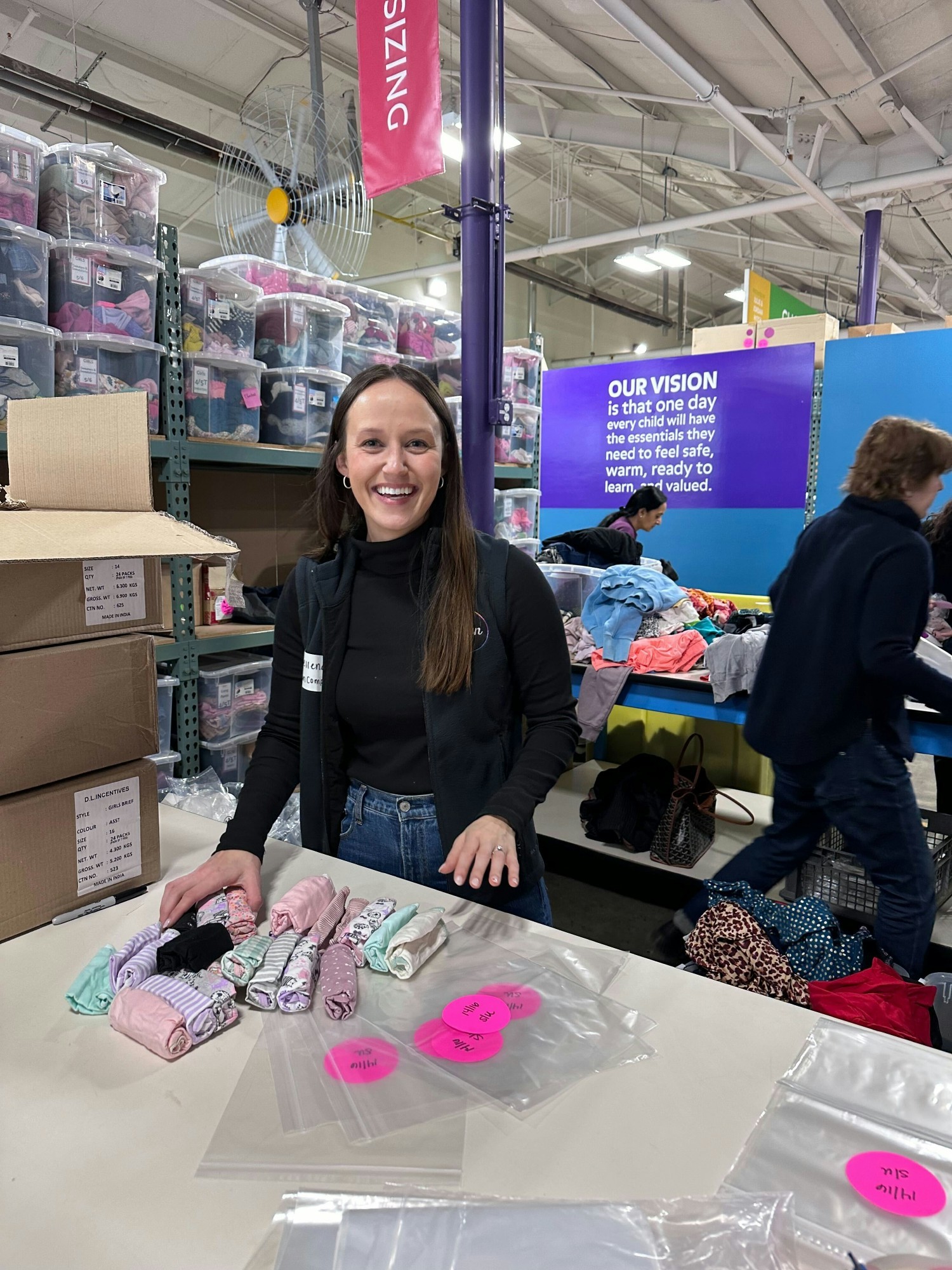 Boston-based colleagues sort and package clothes for children in need around Massachusetts.