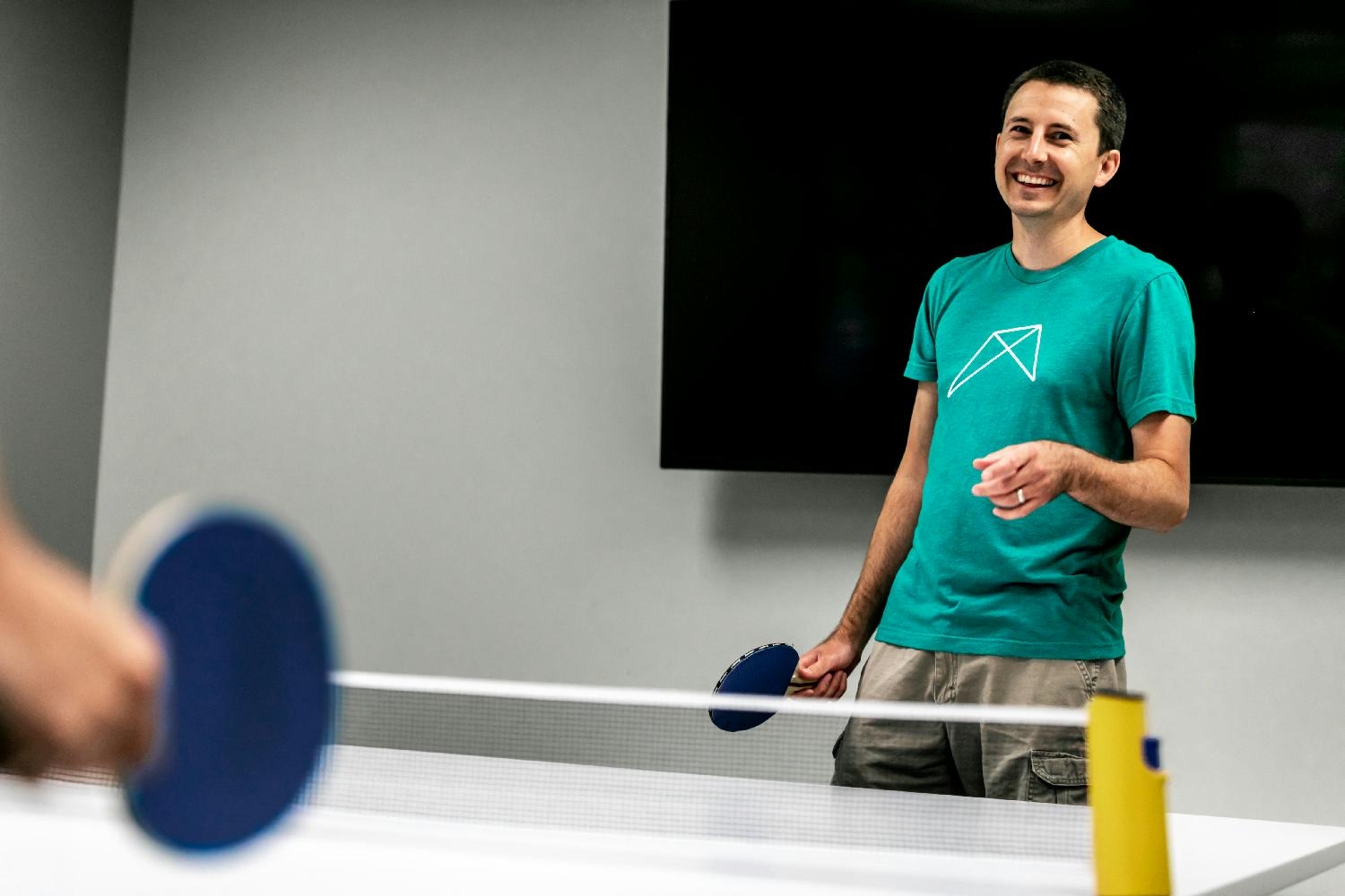 Conference room/ping-pong arena. Brandon, Director of Design and Development, plays a round of pong during Fizzy Friday.