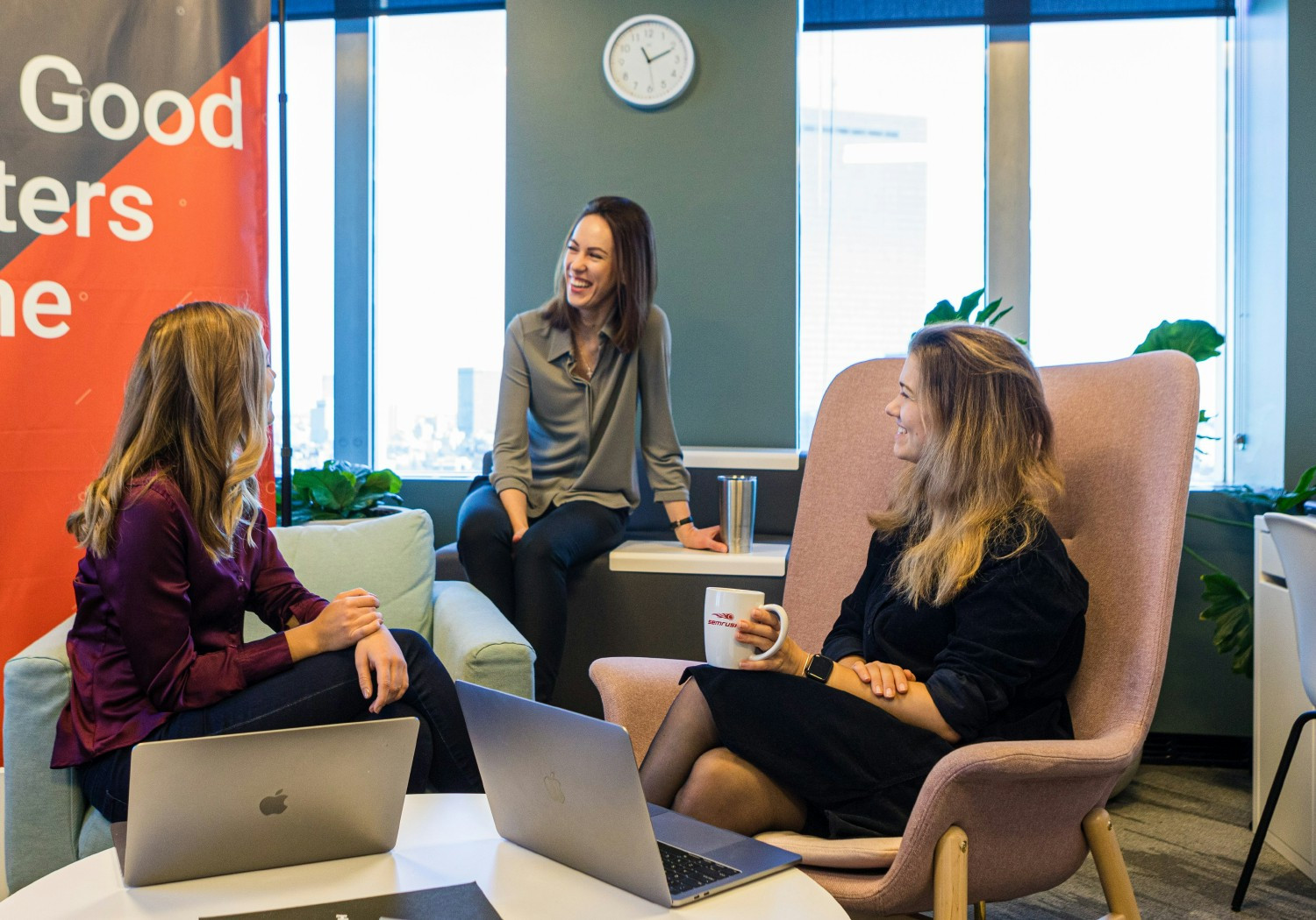 Three employees gather for a meeting in the lounge at the Boston office.