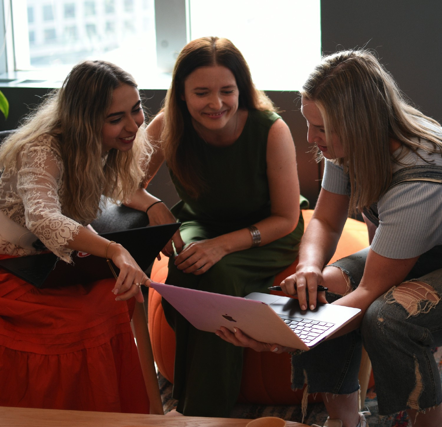 Three employees gather for a meeting in the lounge at the Boston office.