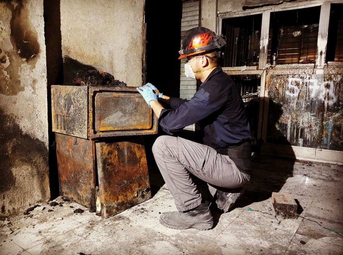 Project Manager Leonel Carrasco inspecting damage at a fire scene