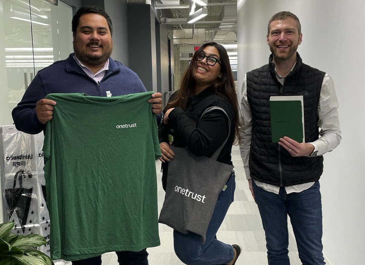 Employees showing off their new OneTrust swag at our new brand launch party in October 2022.