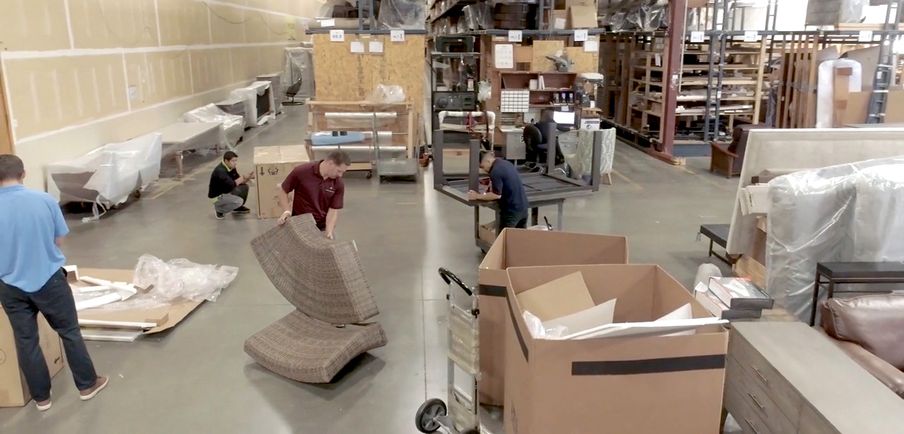 Guys putting together furniture in warehouse.