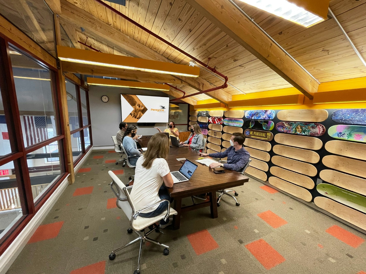 A meeting in the “Board Room” where skateboard decks customized by employees line the walls