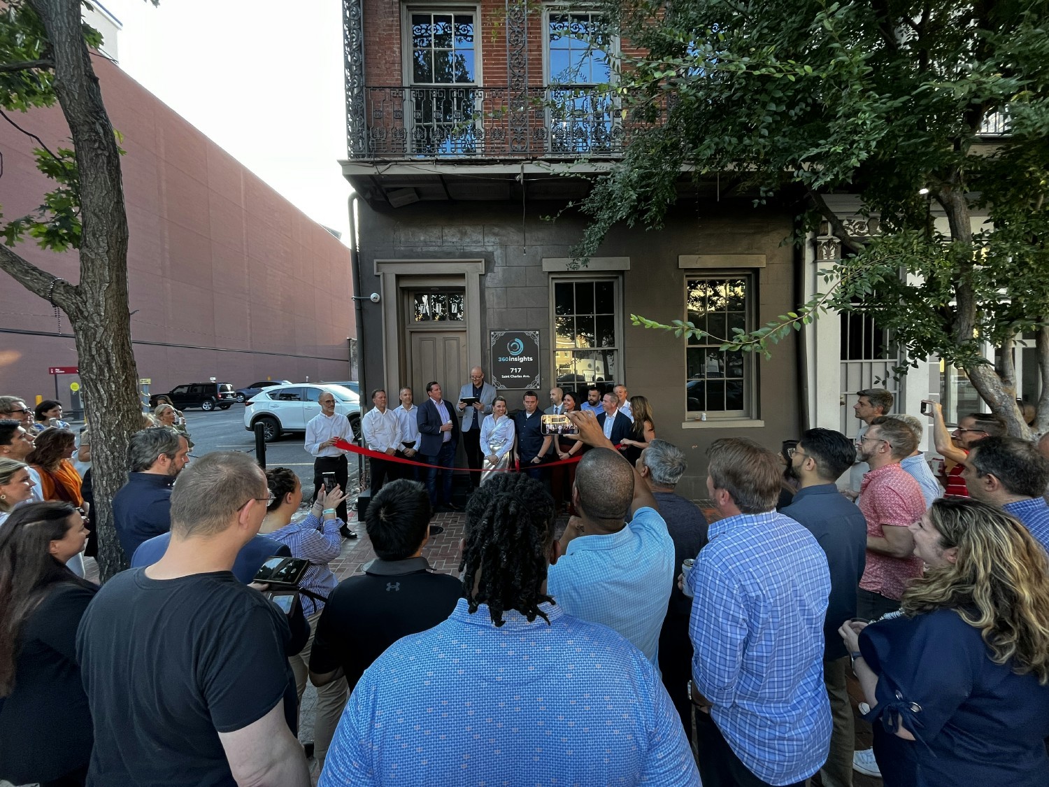 Insighters and community members watch on as our leadership team officially cut the ribbon on our new NOLA office