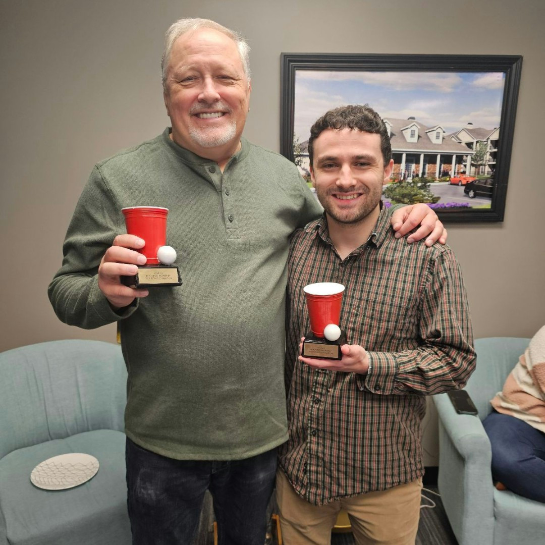 Two of our accountants celebrating their win at the monthly beer pong competition, fostering fun and team spirit
