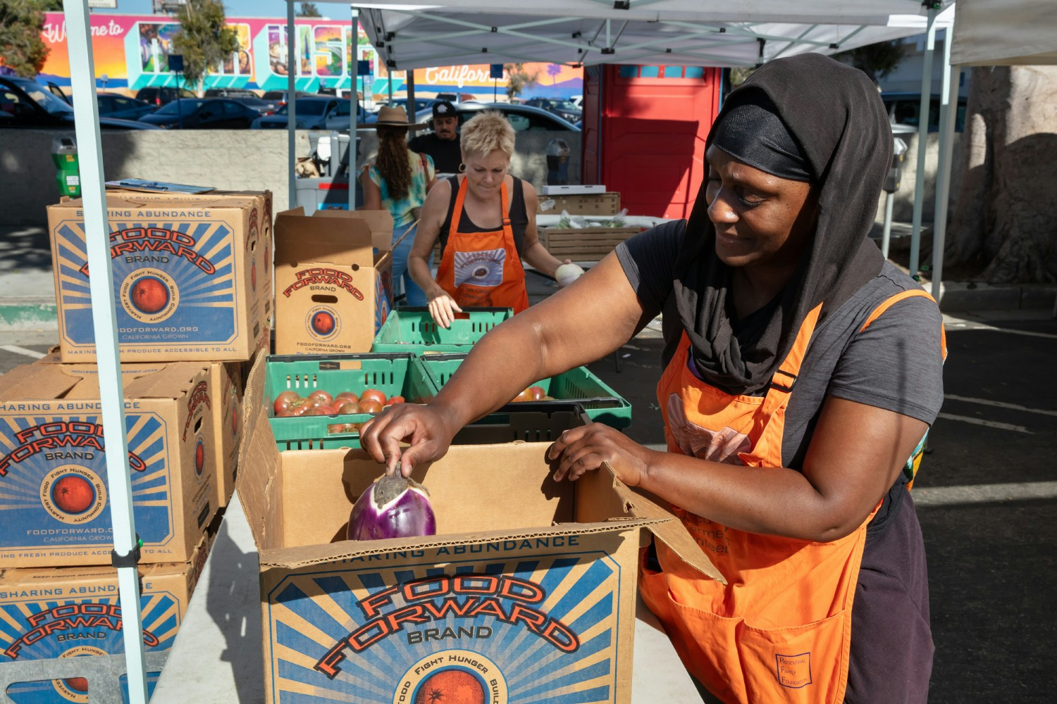 Volunteers load recovered produce  at a farmers market. 
Photo credit: Eron Rauch. Image Food Forward Inc. ©2023.
