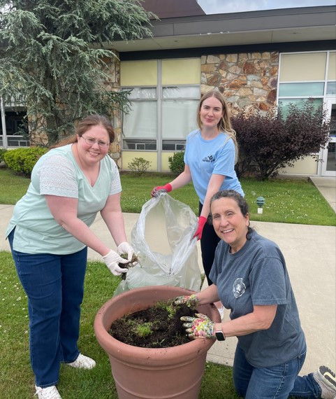 Team members planting flowers at the local Nursing and Rehabilitation Center, bringing smiles to residents.