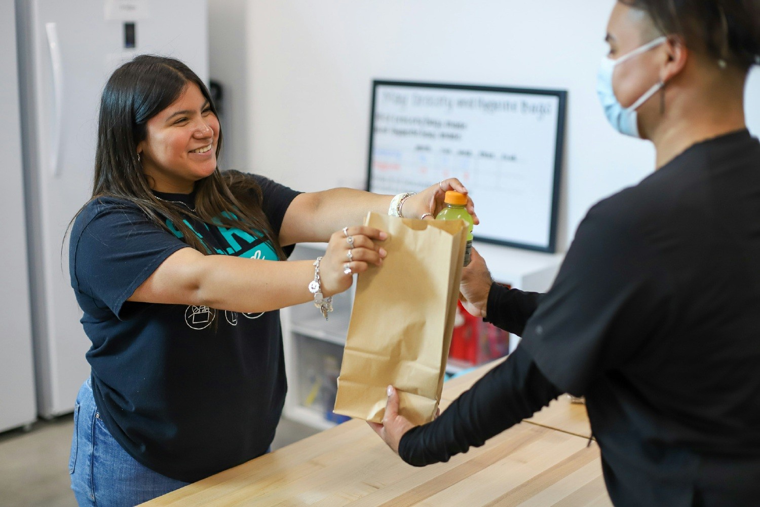  A Palo Alto College employee provides a free meal to a student at the campus food pantry