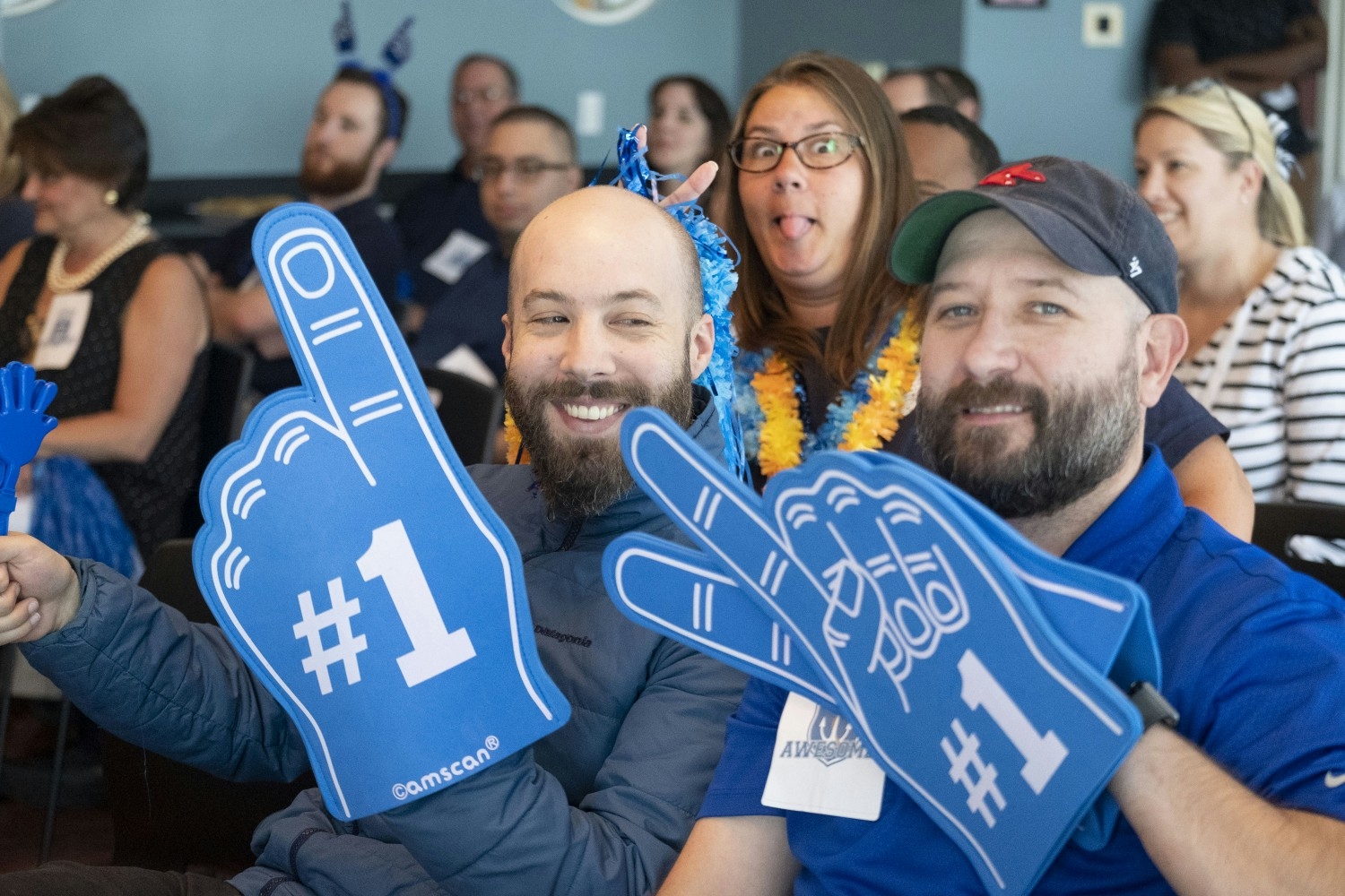 Ian Otenti and Joel Young cheering on their team during a company team-building gameshow.