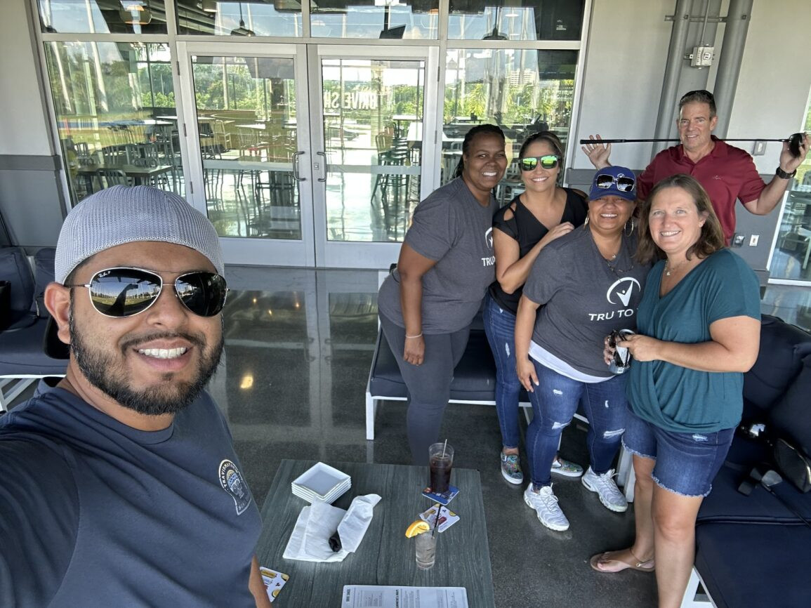 Employees near Palm Beach Gardens enjoy happy hour together at Top Golf.
