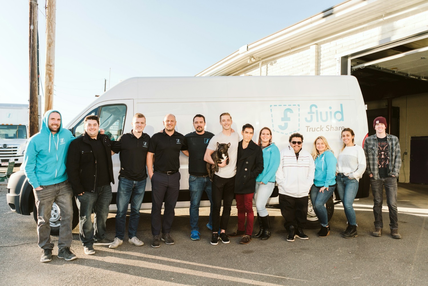 Fluid Truck staff pose for a photo in front of a vehicle available for rent on our platform.