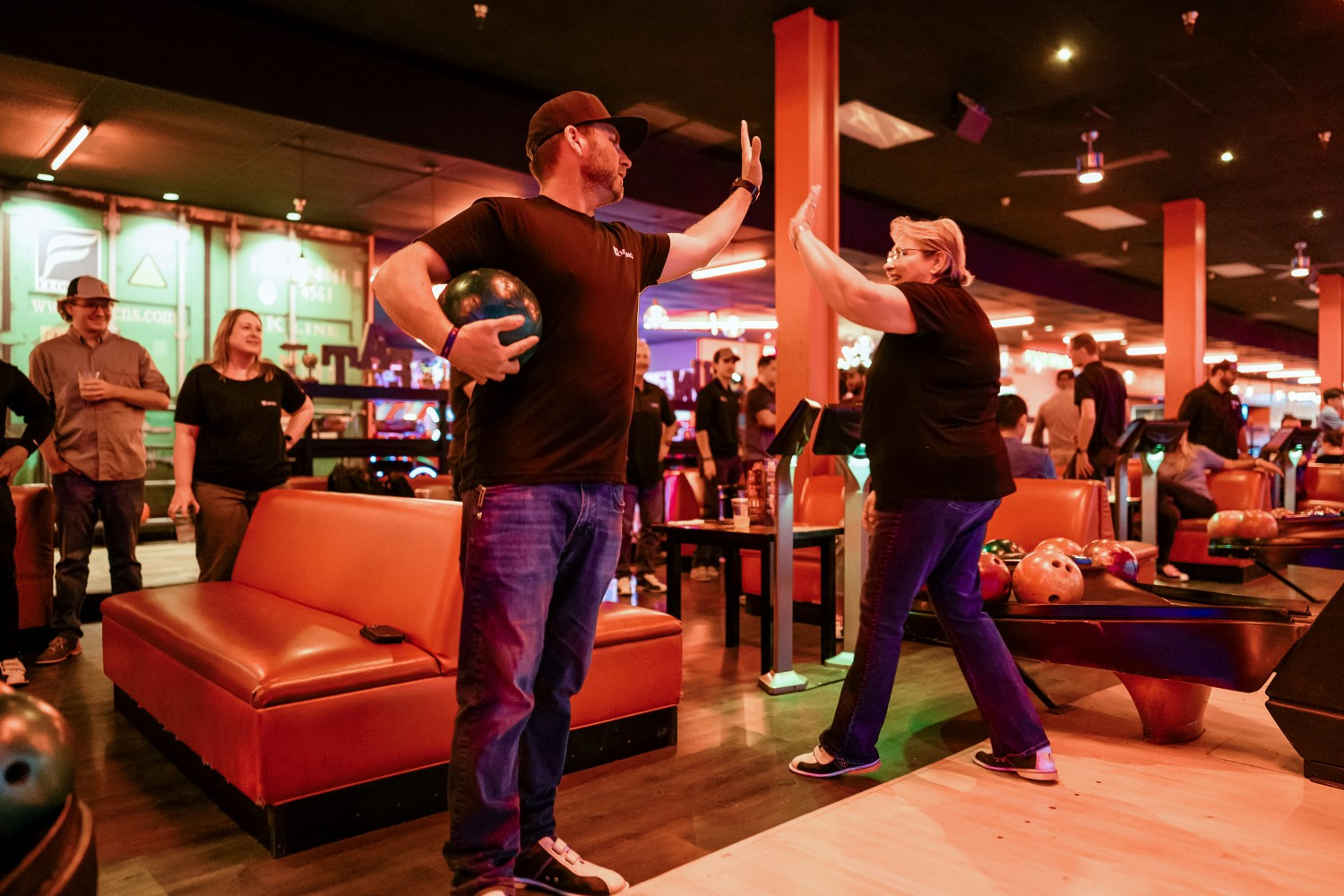 Bowling - Employees celebrate with a high-five during one of Quiring’s team bonding events