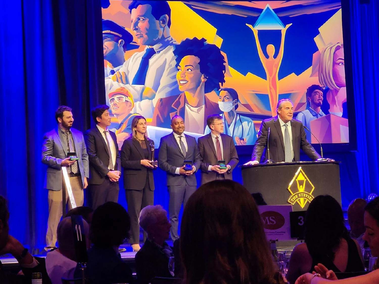 Dean Leavitt and members of the Technology organization on stage at the American Business Awards