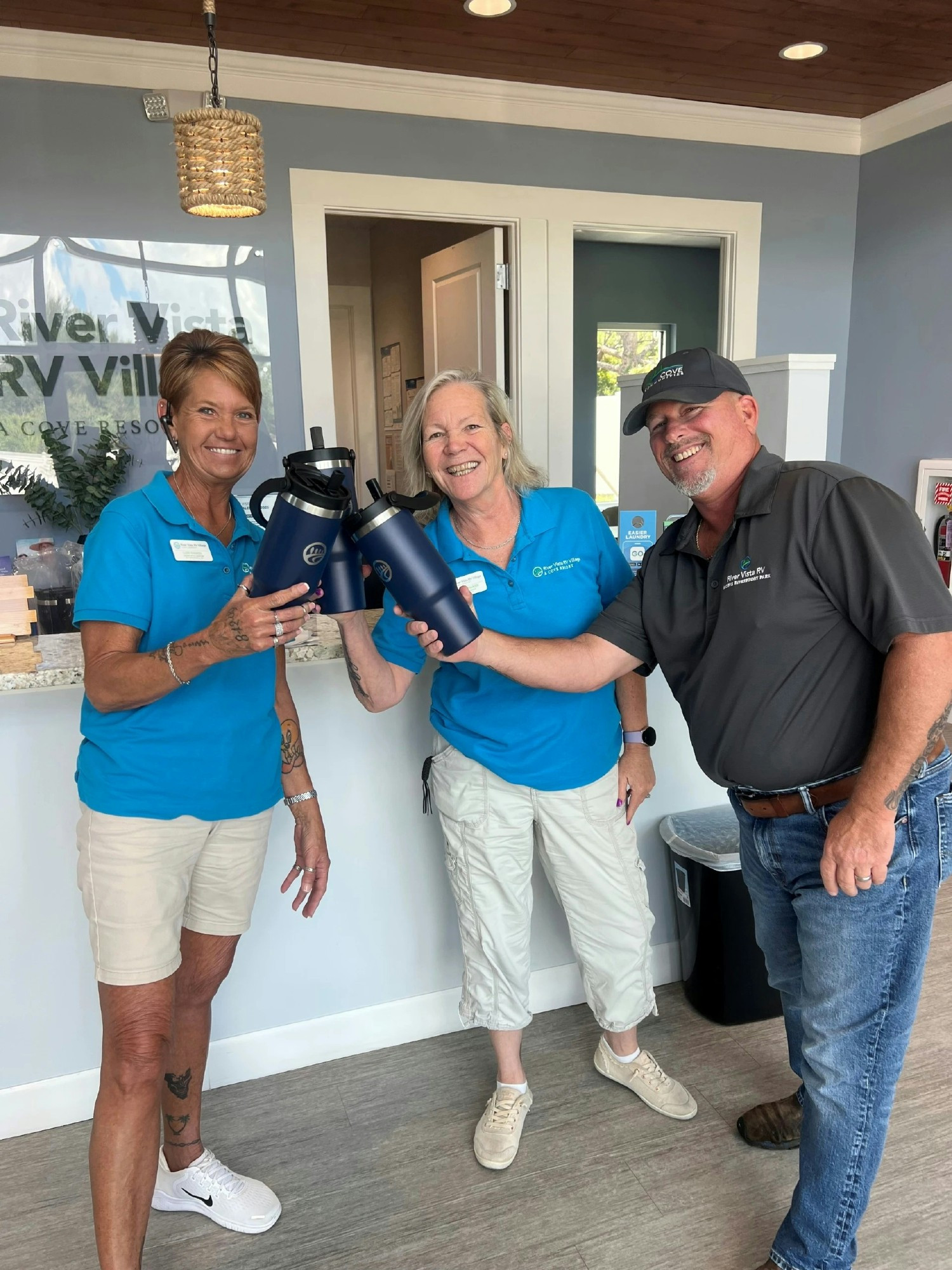 Team members show off new Cove water bottles during the summer Beat the Heat campaign.