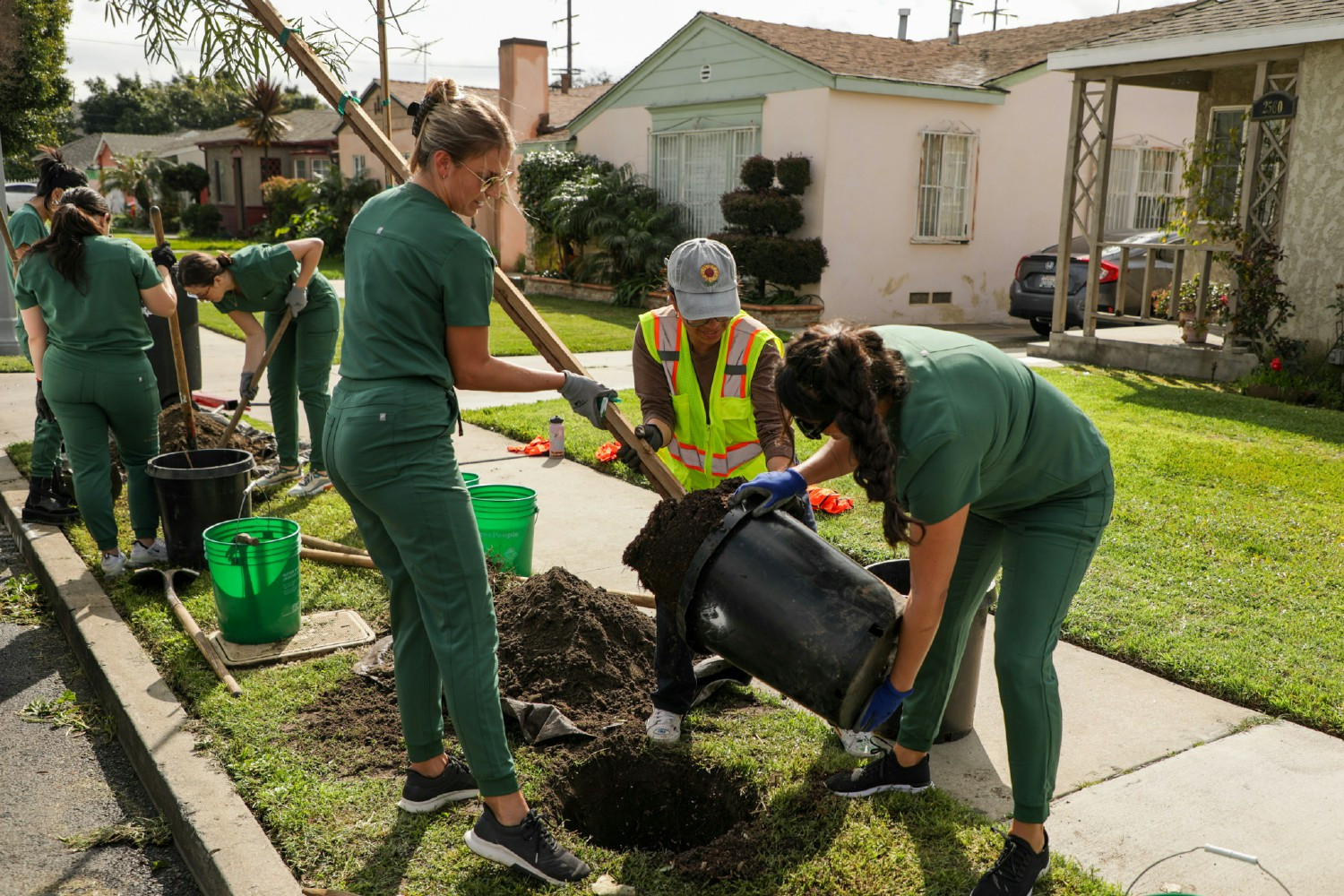 The Scrubs team planted trees in honor of Earth Day, wearing our scrubs in April's feature color: Hunter Green.