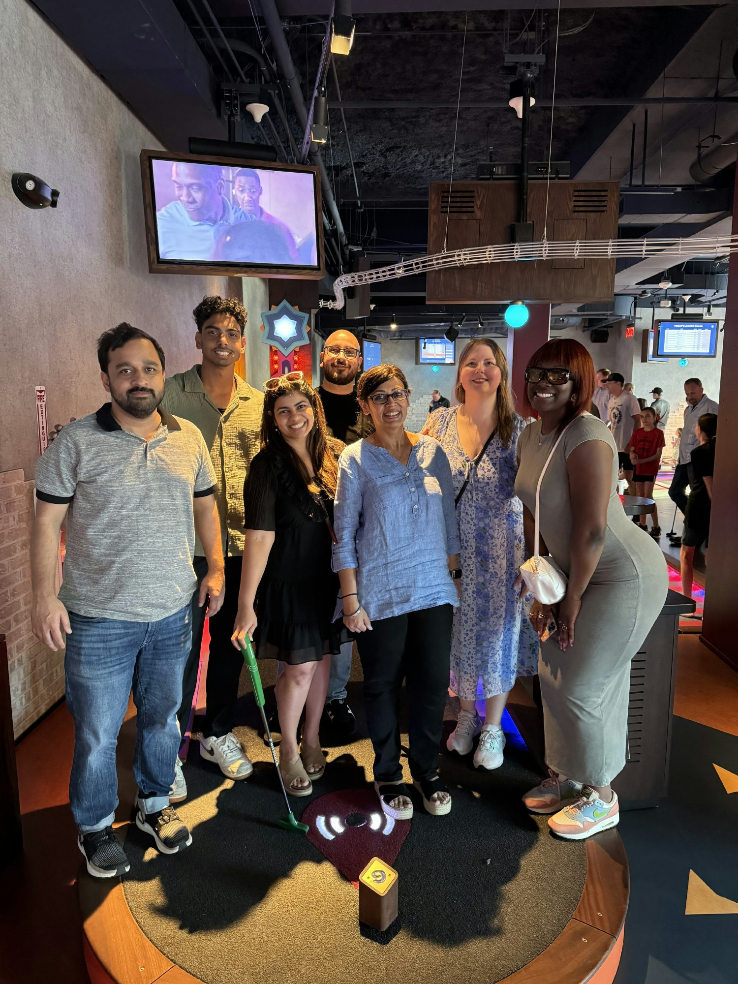Collegues taking a break to enjoy mini-golf as part of a team building exercise.
