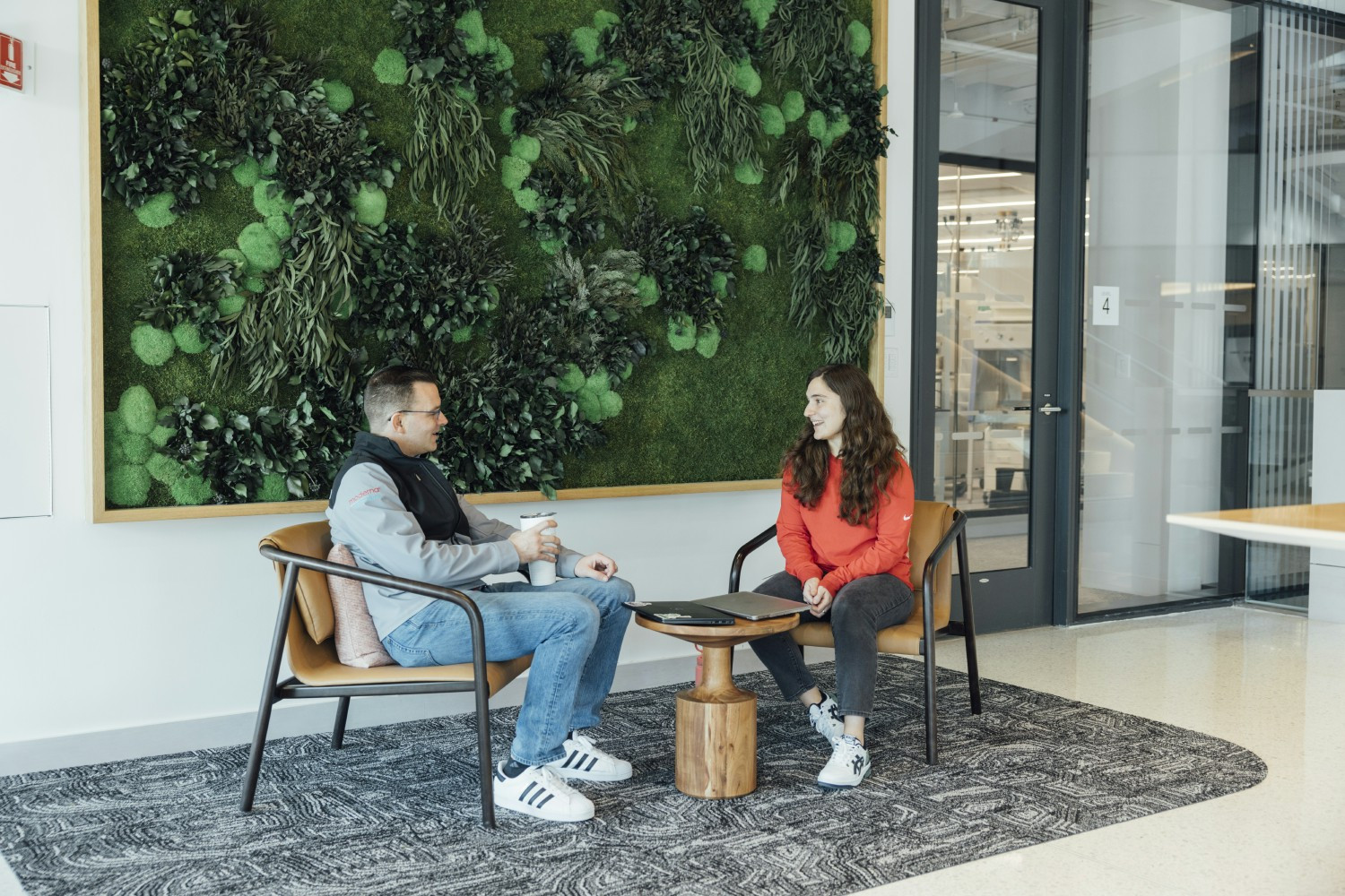 Two Moderna colleagues enjoy a casual conversation at Moderna's new global headquarters