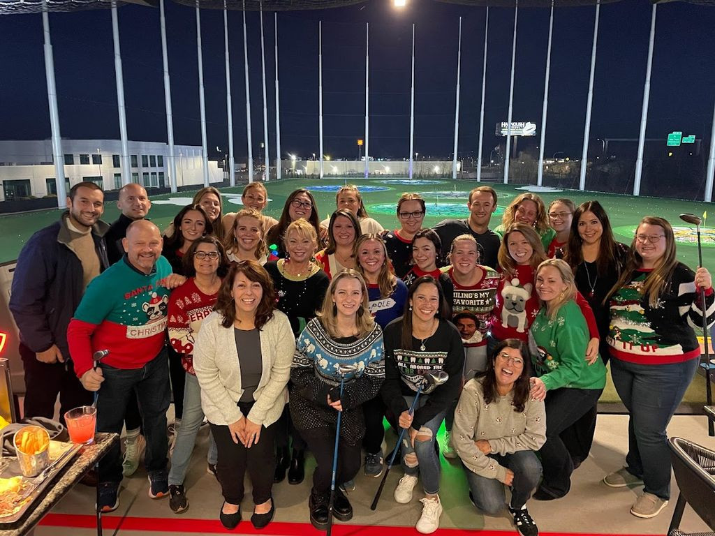 Team Smiles celebrating the holidays for their annual party at Top Golf. 