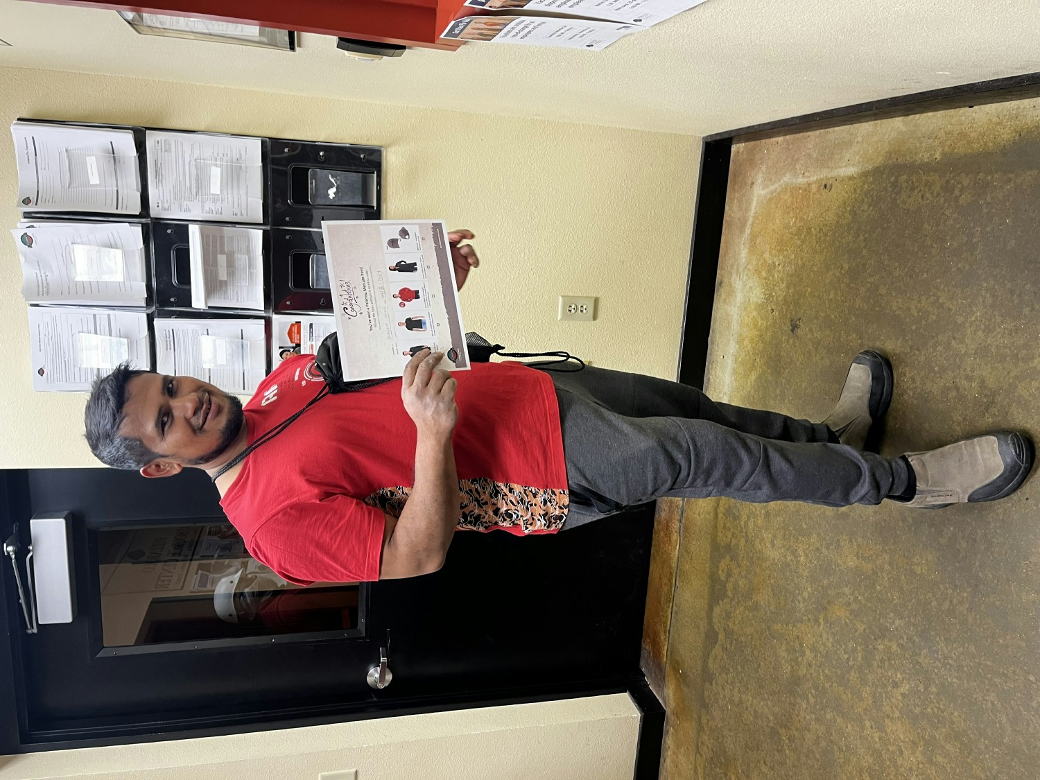 An employee shows off the certificate he won after being nominated the 