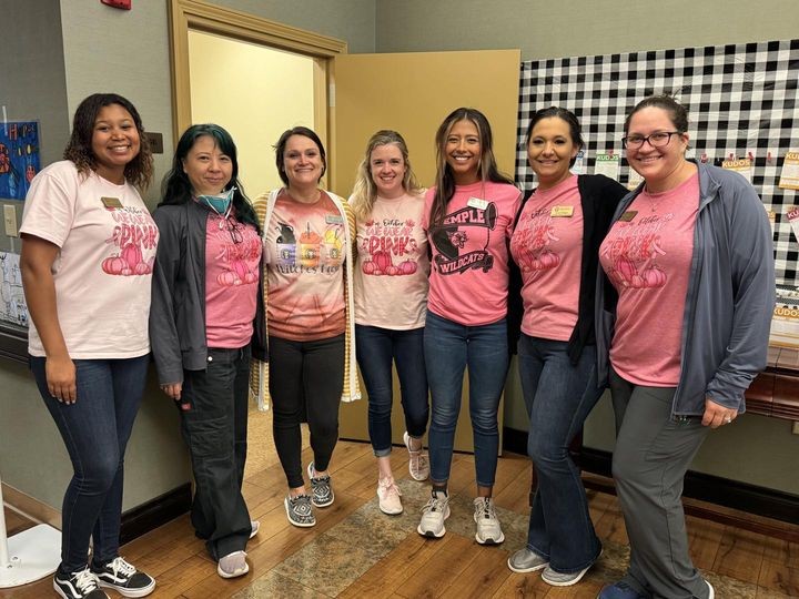 Team members wearing pink to support breast cancer awareness.