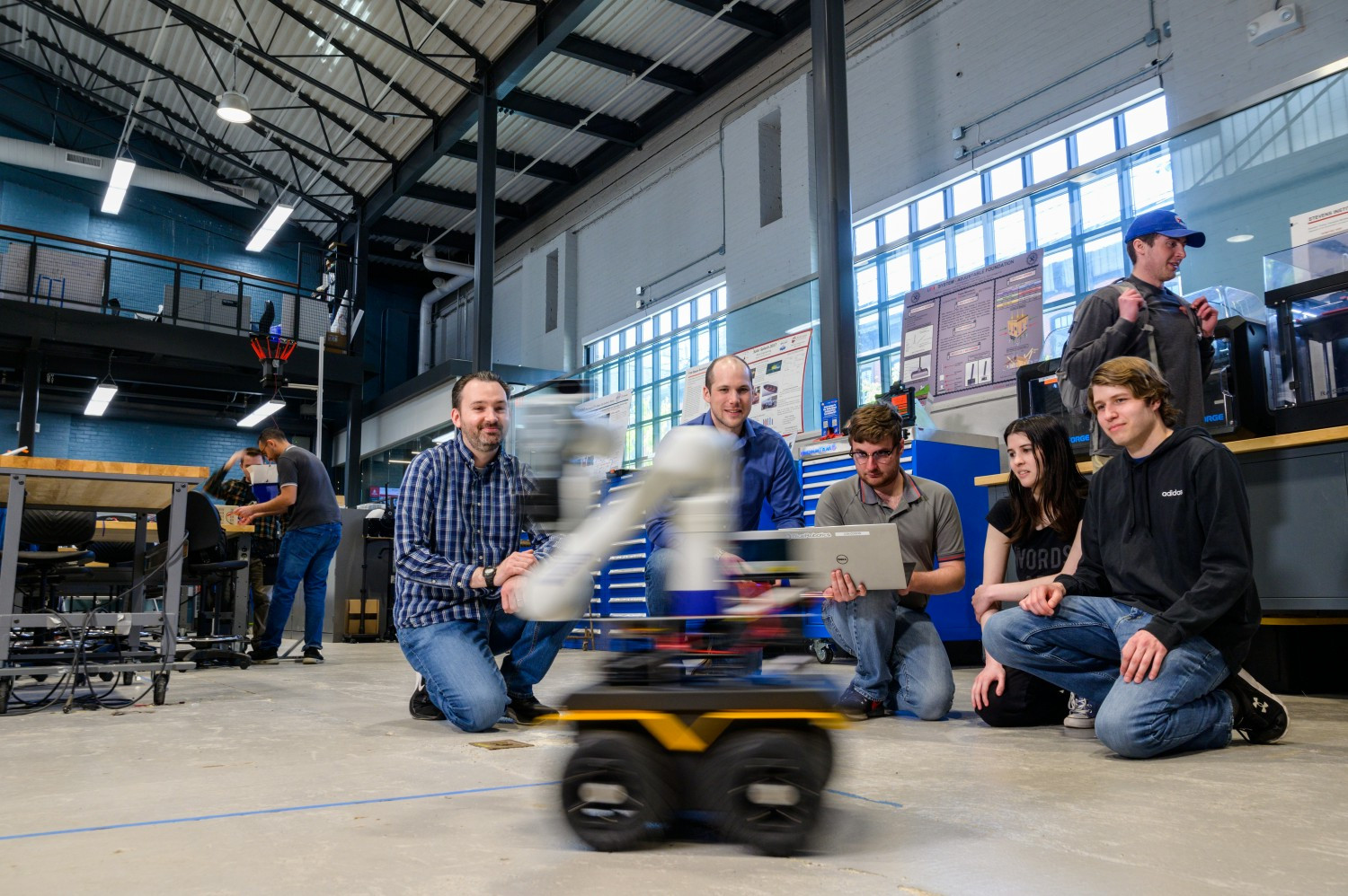 Director of Stevens Institute of Artificial Intelligence Brendon Englot, left, works with a student team. 