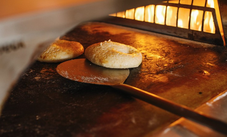 Our fire-baked focaccia bread cooking in the hearth oven