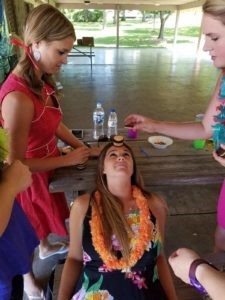 Employees at one of our picnics - most wore beach-theme clothes - playing a minute-to-win-it type game