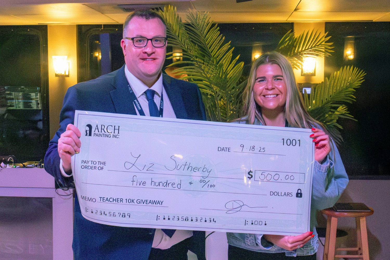 Arch Painting CEO Richard Kilgannon presents a check to one of the $10K Teacher Giveaway winners, Liz Sutherby