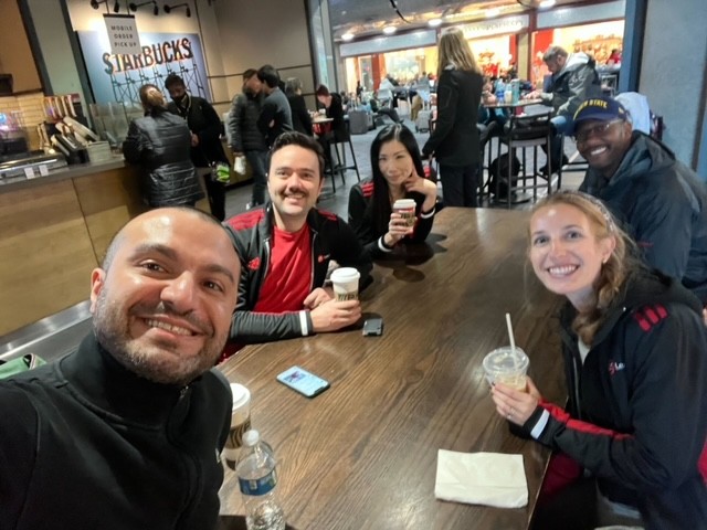 Team picture grabbing coffee at an airport during a company trip. 