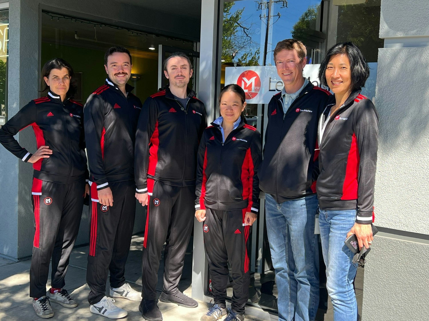Karl Harris CEO with team showing off our new company branded tracksuits in Menlo Park, CA. 