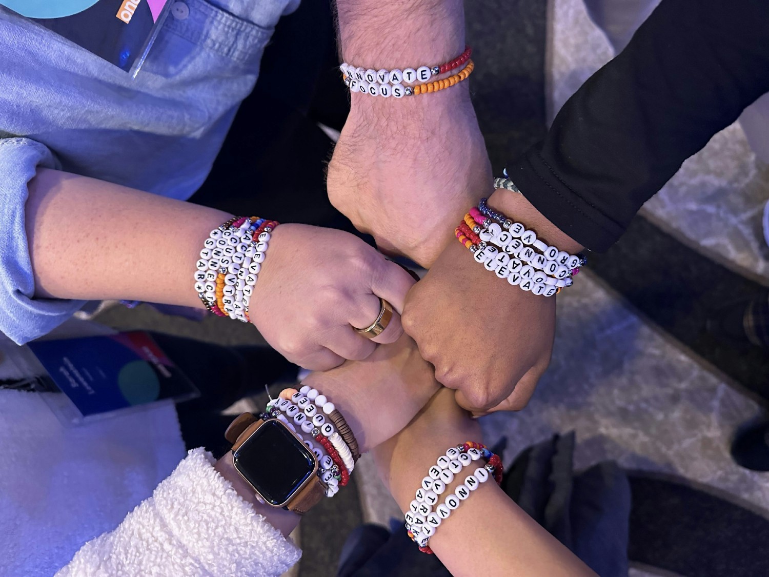 Team members sporting bracelets that were given and traded at our in-person All Hands 