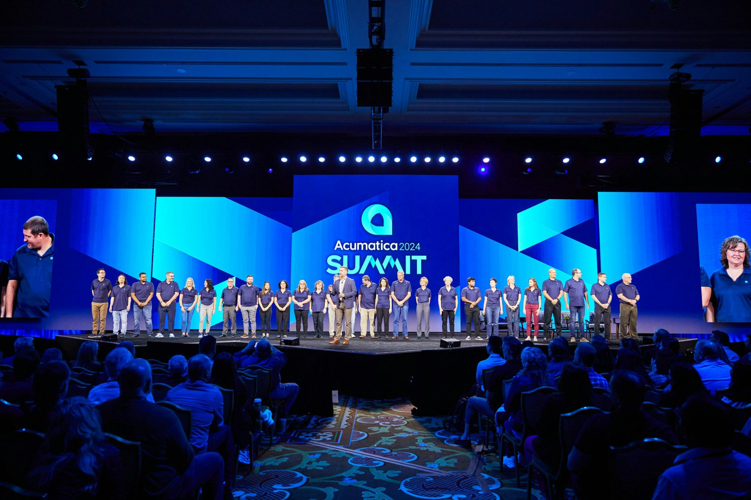 John Case, CEO, is joined on stage by Acumatica employees at company's 2024 Acumatica's Summit event. 